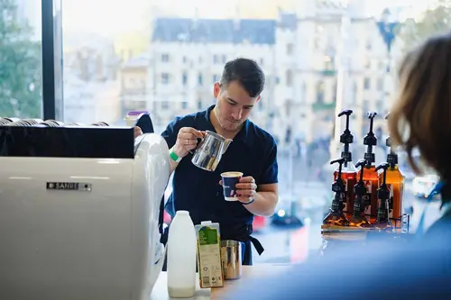 Barista pouring coffee at London insurance conference